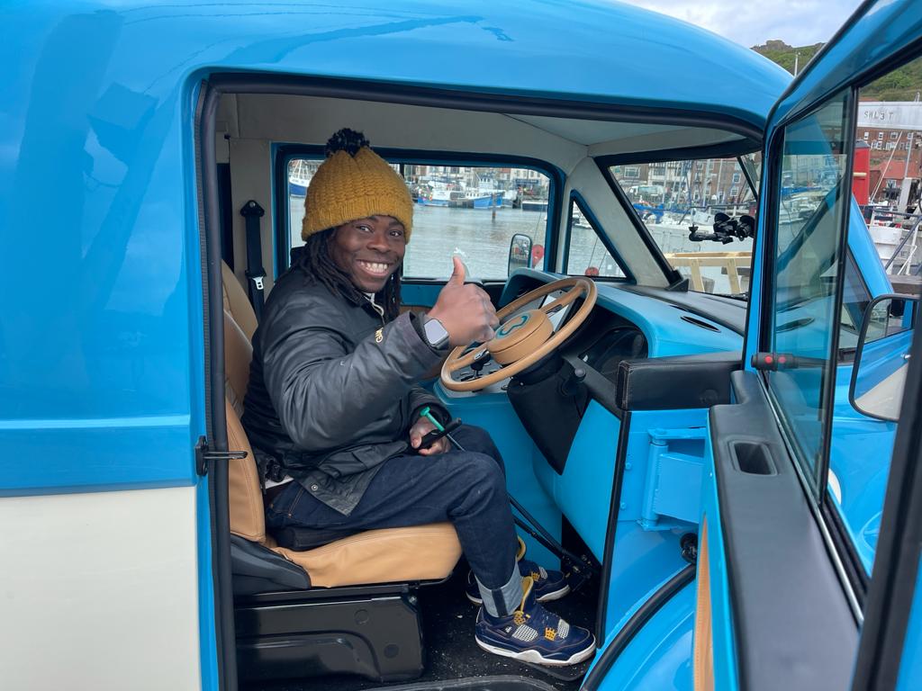 Ade Adepitan driving the Morris JE1 as part of filming for the BBC The Travel Show